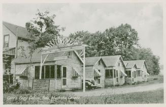 Black and white photograph of four housekeeping cabins.