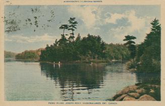 People canoeing near the wooded shoreline of a lake.