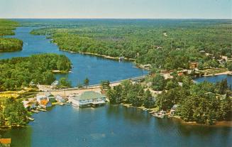 Color aerial shot of a cottage community on a lake.