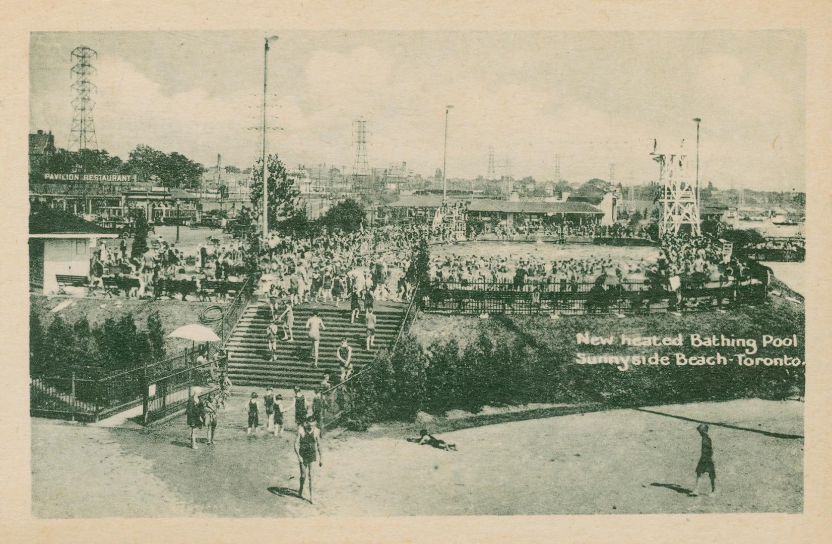 Distant view of large swimming pool and crowds of swimmers with beach and stairs to pool in for ...