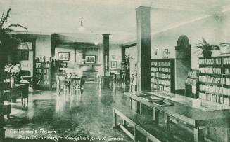 Picture of room in a library with large table and bench and book shelves lining the walls. 