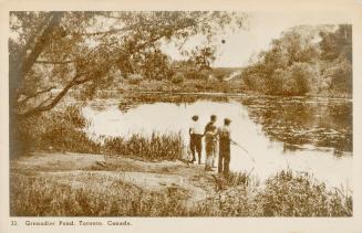 Sepia toned picture of three boys standing b the edge of a pond in a wooded area.