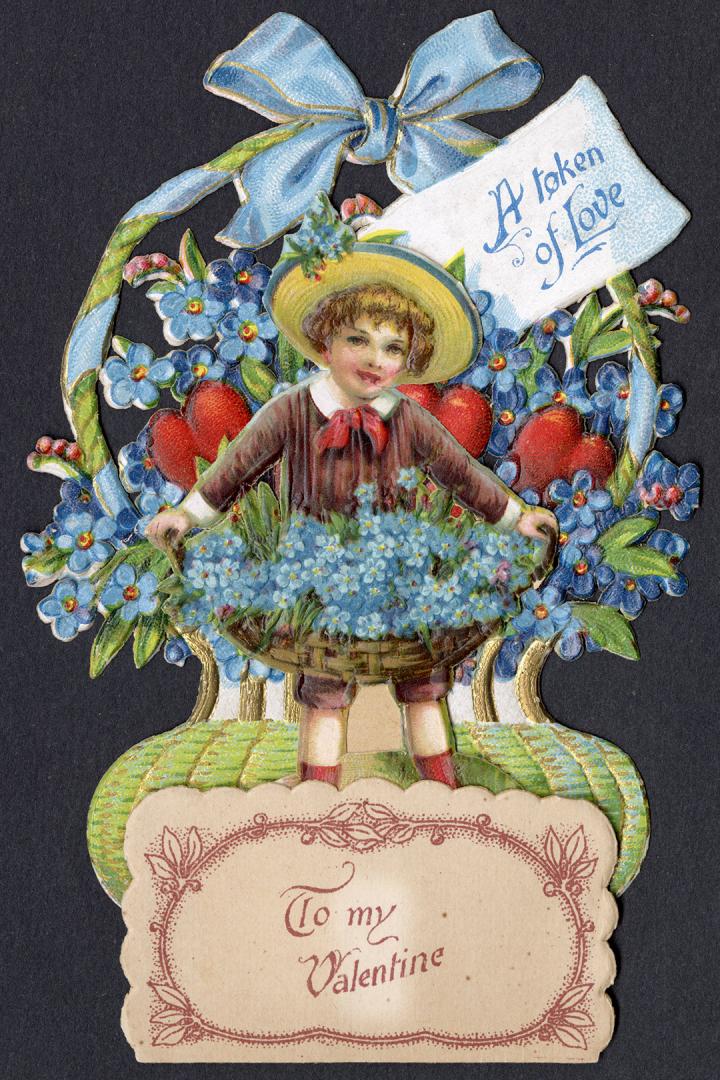 A pop-up card.Foreground: A boy with a large sun hat and brown suit holds a huge basket of blue ...