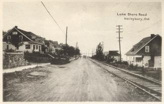 Photograph of houses lining a street in a small town.