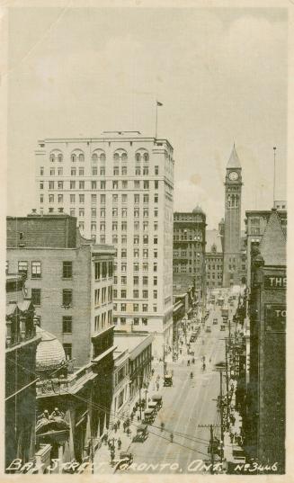 Black and white photograph, taken high above a busy city street.