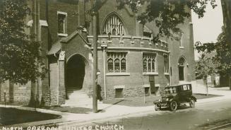 Picture of church building with automobile parked out front. 