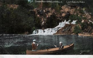 Colorized photograph of two men in canoe fishing in water in front of waterfalls.