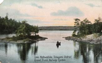 Colorized photograph of a lake in the wilderness with a lone canoeist.