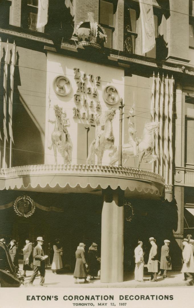 Picture of front entrance of store decorated with coronation flags and banners.
