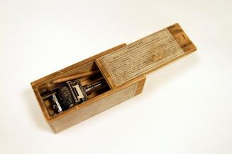 A wooden box with a handheld dating device inside. 