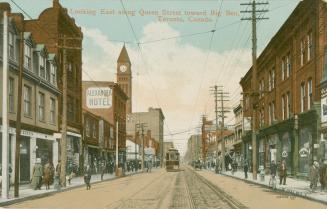 Picture of a street with City Hall tower on left and buildings on both sides and streetcar in m ...