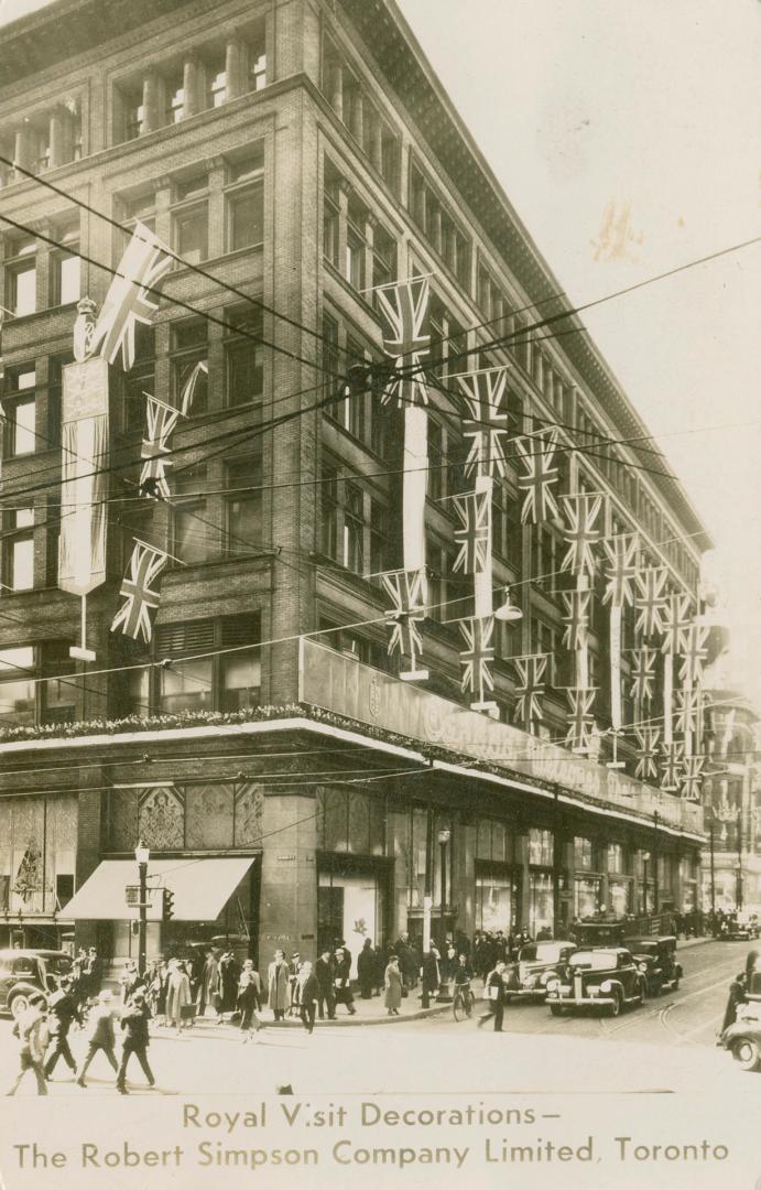 B/W postcard depicting a photo of Simpsons Department Store decorated with British flags with c ...
