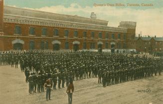 Colorized photograph of a large group of soldiers mustered in front of a large castle-like buil ...