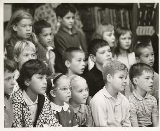 Photo of a group of children watching a magic show. 