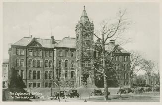 Black and white photograph of a four story collegiate building with a central tower