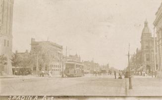 Sepia toned photograph of a city street with a streetcar running down the middle.