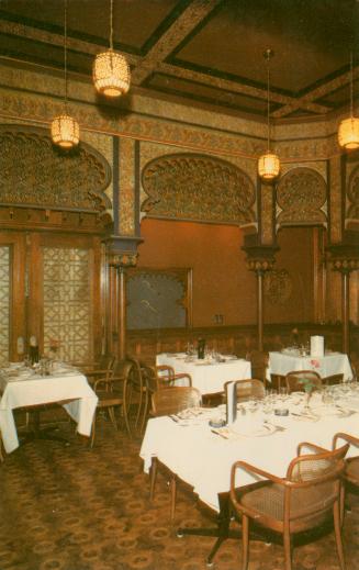 Color photograph of a large dining room of Moorish design.