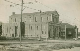 Black and white photograph of a large two story church.