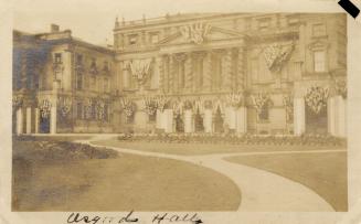 A photograph of a large hall with multiple arched entrances, columns above the front of the bui ...