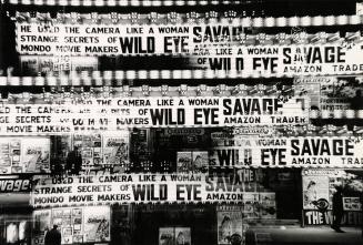 A multi-exposure photograph of the marquee and various posters in front of a movie theatre. The ...