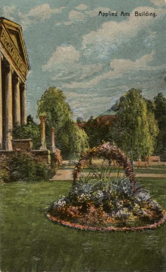Colorized photograph of a circular flower bed in a lawn outside a classical style building with ...