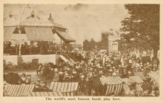 Sepia toned photograph of a crowd of people sitting in chairs around a raised round bandstand w ...
