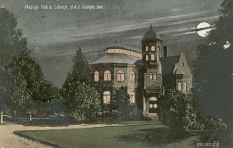 Picture of large library building with tower at night with a full moon. 