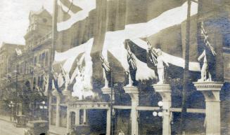A photograph of storefront decorated with bunting and flags of the United Kingdom. The words "E ...