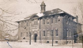 Black and white photograph of a two story school building with a central turret.