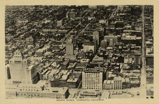 Black and white aerial photograph of the downtown of a large city with skyscrapers.