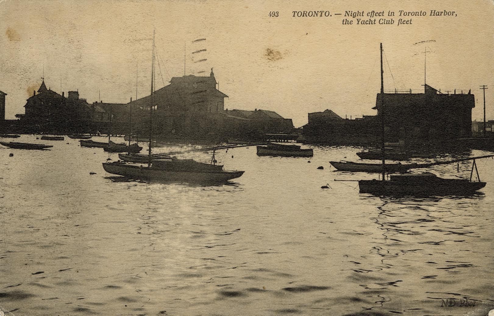 Sepia-toned photo postcard depicting the Toronto harbor with boats and yachts on the water. The ...