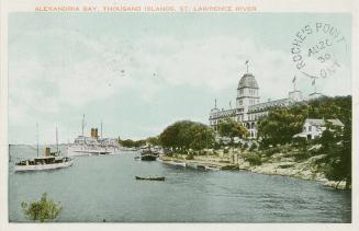 Colorized photograph of a view of a waterway, with a large summer resort on the river bank.