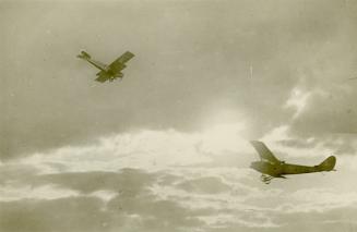Black and white photograph of two biplanes in flight