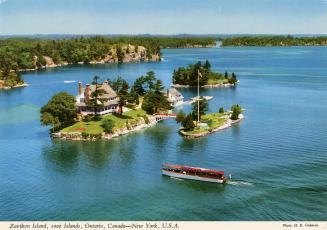 Color, aerial photograph of a view of a waterway, with a large home on an island connected by a ...