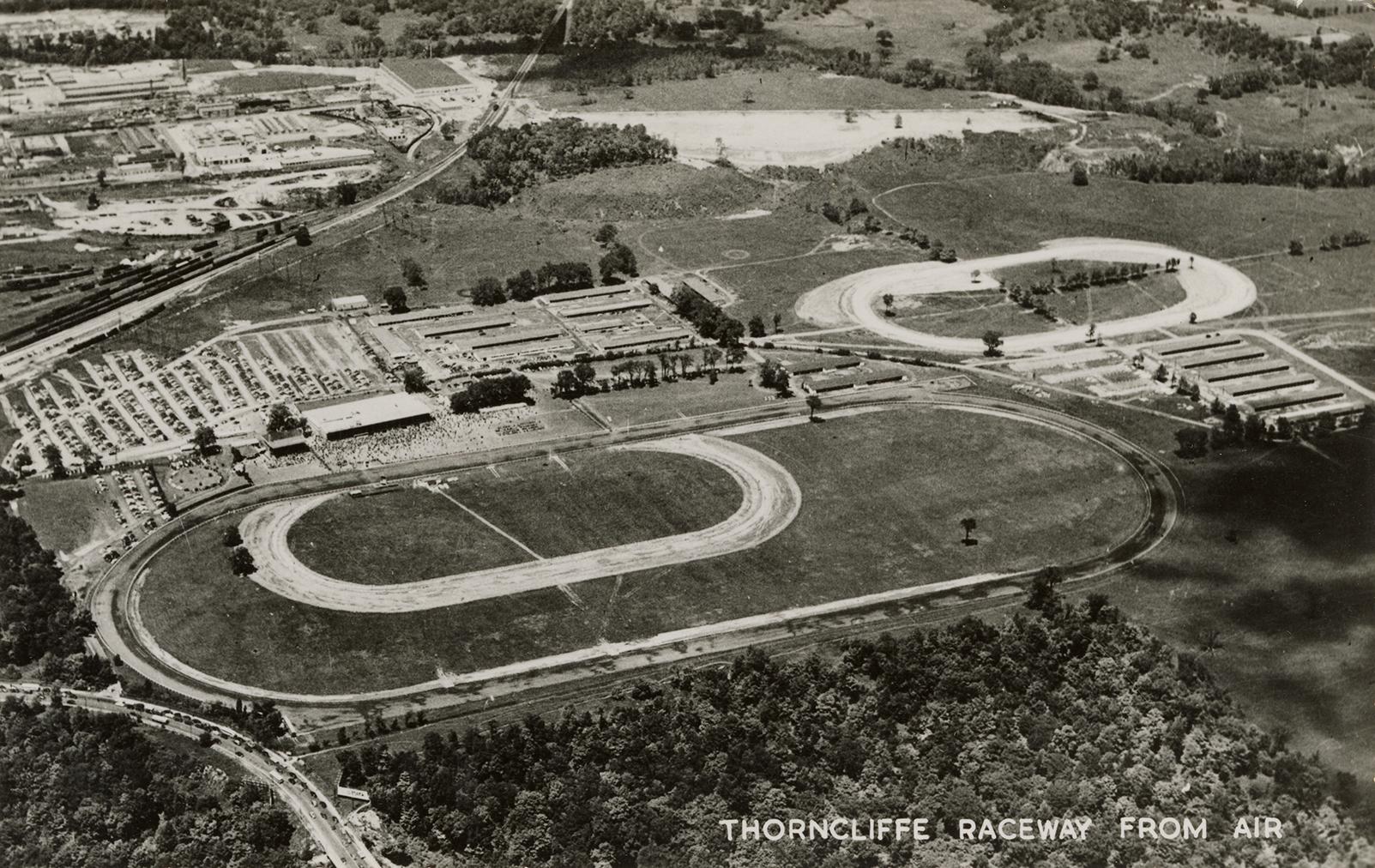Black and white photo postcard depicting an aerial view of oval tracks. The caption on the bott ...
