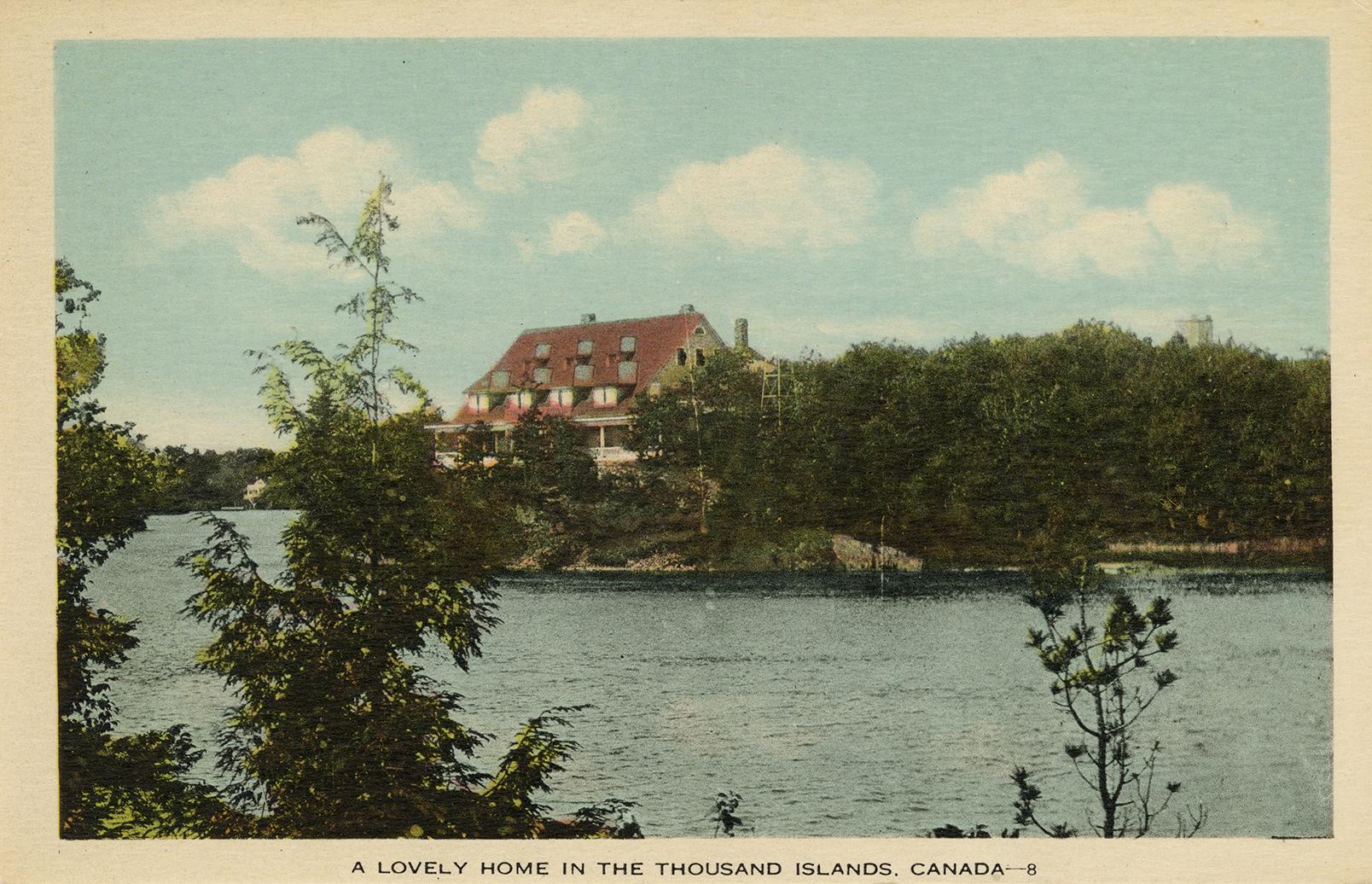 Colorized photograph of a large house on a small island in the middle of a river.