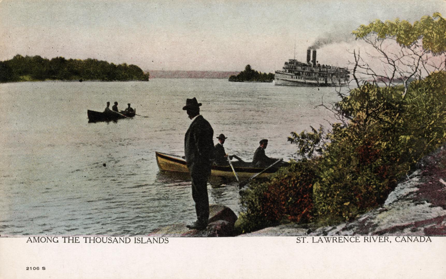 A man is standing on a shoreline watching people in row boats and a steamship in the distance.