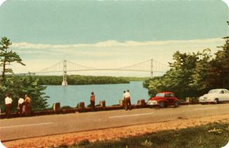 Colorized photograph of people who have step out of their automobiles to look at the view of an ...