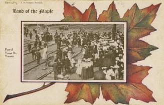 Colour photo postcard depicting depicting a crowd of pedestrians crossing over rail tracks to r ...