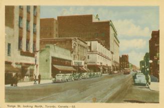 Colour photo postcard depicting a view of Yonge Street looking north from Gerrard with cars par ...