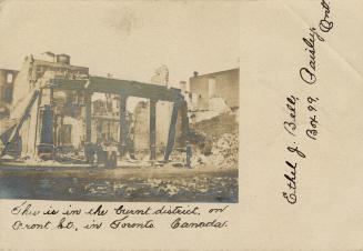 Black and white photograph of a large building in ruins after being gutted by a fire.