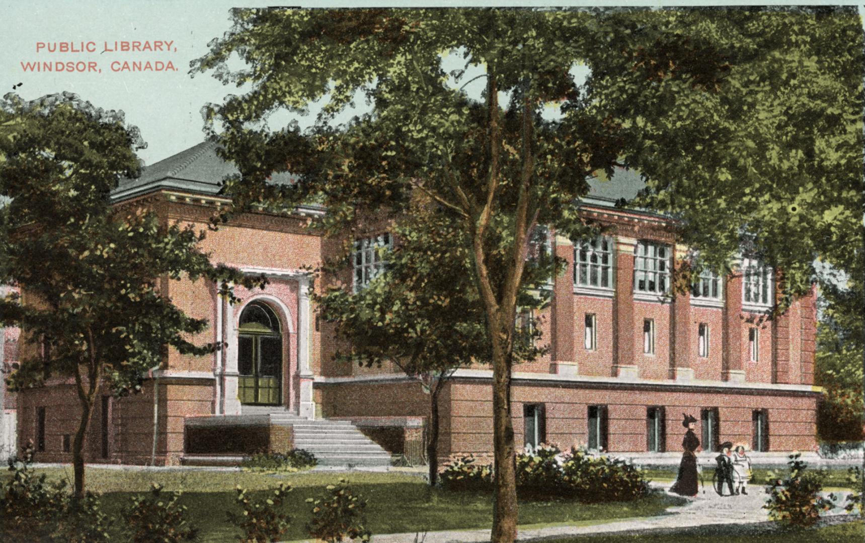 Picture of large brick library building with trees in front. 