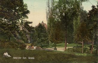 Colorized photograph of a wooded area with people relaxing. Wooden bridge is on the left.