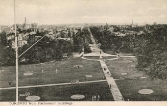 Black and white photograph of a large park with tall buildings in the background.