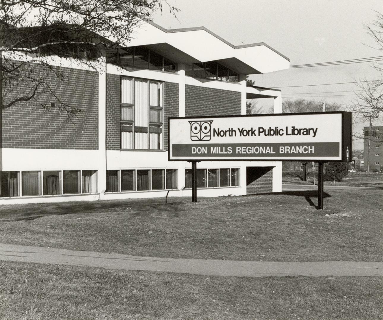 Picture of a library building with sign out front. 