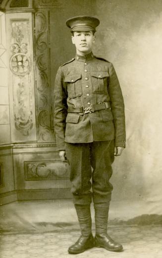 Black and white pictures of soldier posing for a photograph, standing at attention.