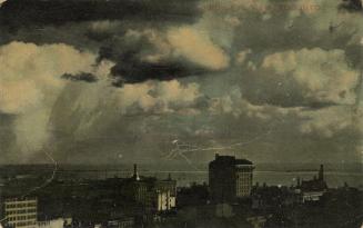 Colorized aerial photograph of skyscrapers in a large city, taken at night.