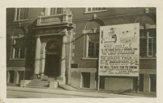 Black and white photograph of a front doorway to a large brick building.