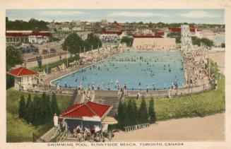 Colorized photograph of many people swimming in a huge public pool surrounded by a beach.