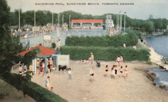 Colorized photograph of many people swimming in a huge public pool surrounded by a beach.